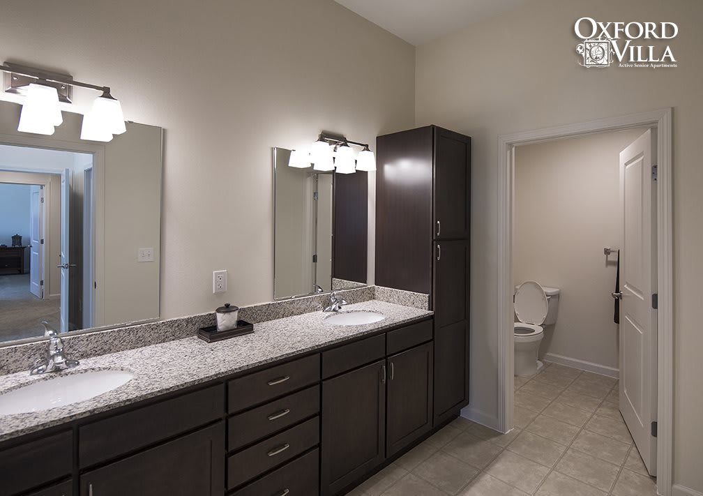 Modern bathroom with double sink vanity and bright lighting.