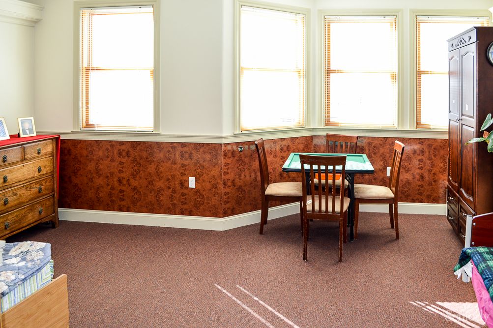 A small dining area with a table and chairs, illuminated by natural light from nearby windows.