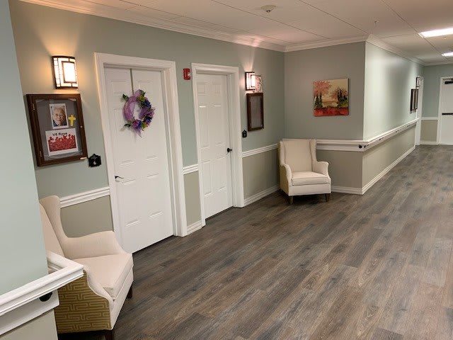 A cozy waiting area with comfortable chairs, soft lighting, and decorative elements like a wreath and artwork on the walls.