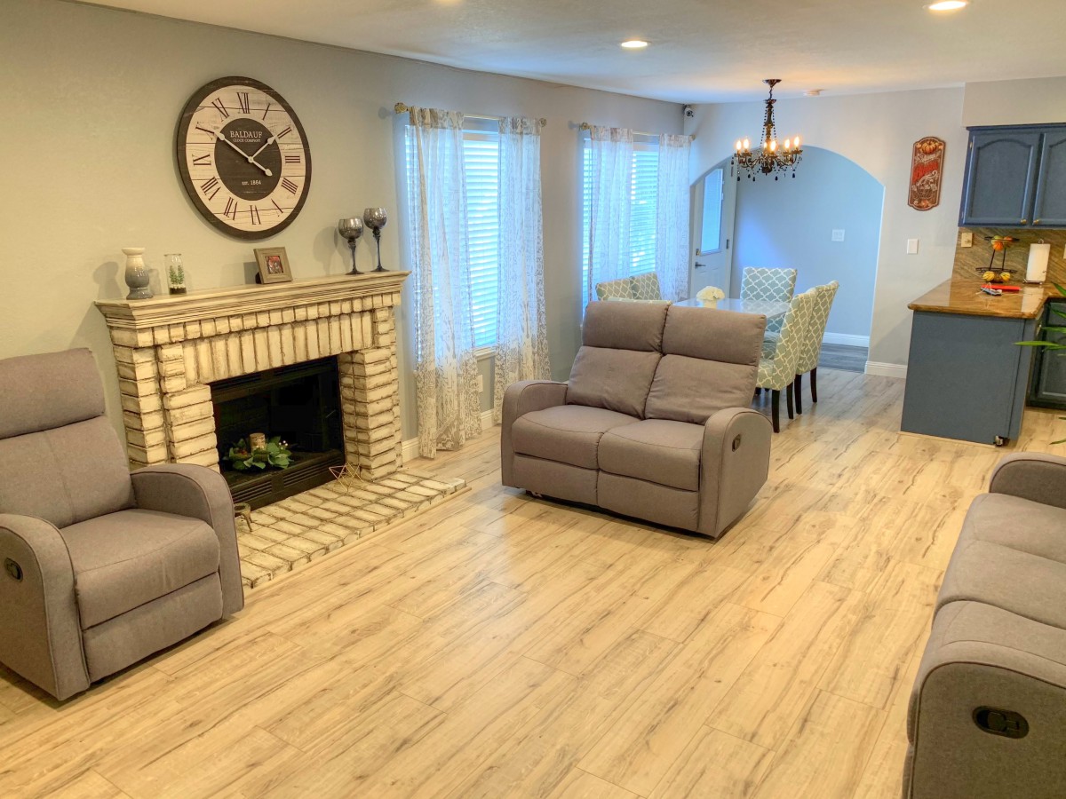 A cozy living room with a modern fireplace, comfortable seating, and a dining area.