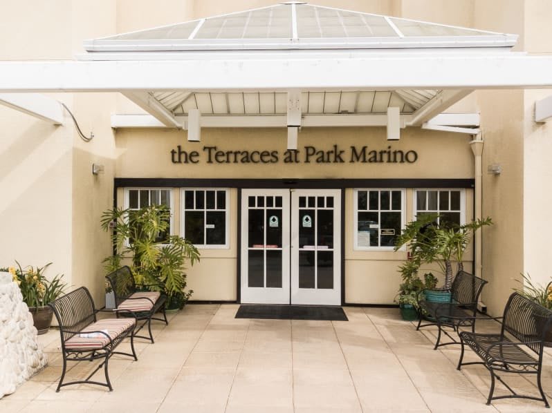 Entrance to The Terraces at Park Marino with an inviting seating area and plants.