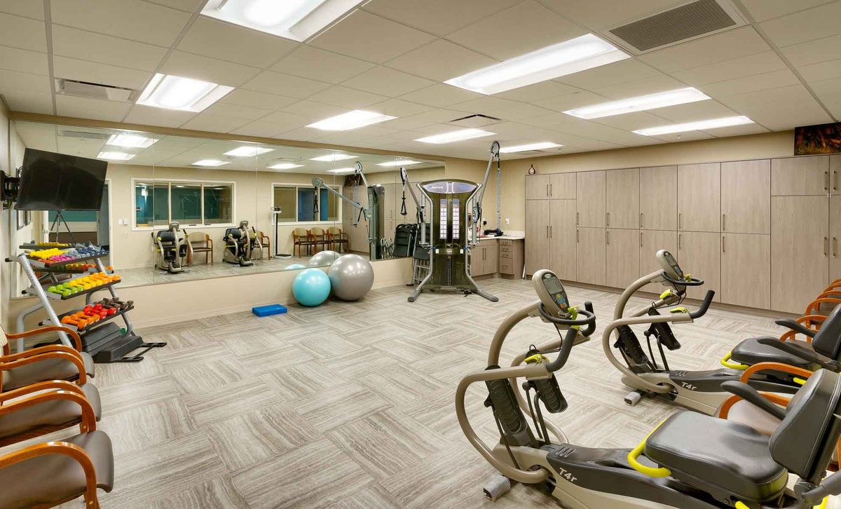 A modern gym with various exercise equipment, including exercise bikes and fitness balls.