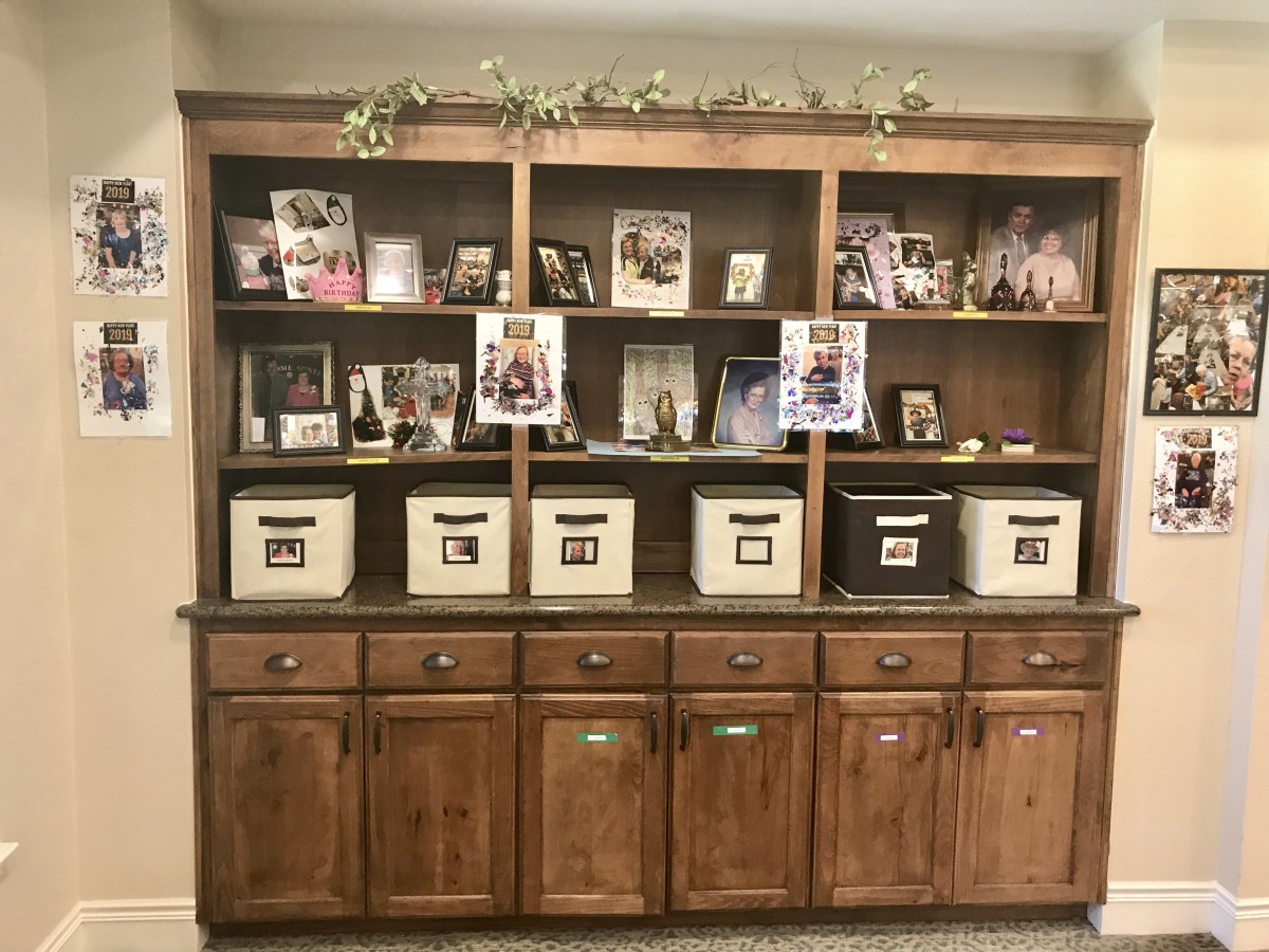 A wooden bookshelf displaying family photos and storage bins in a cozy home setting.