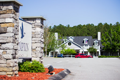 A welcoming entrance to a facility with neatly landscaped surroundings.