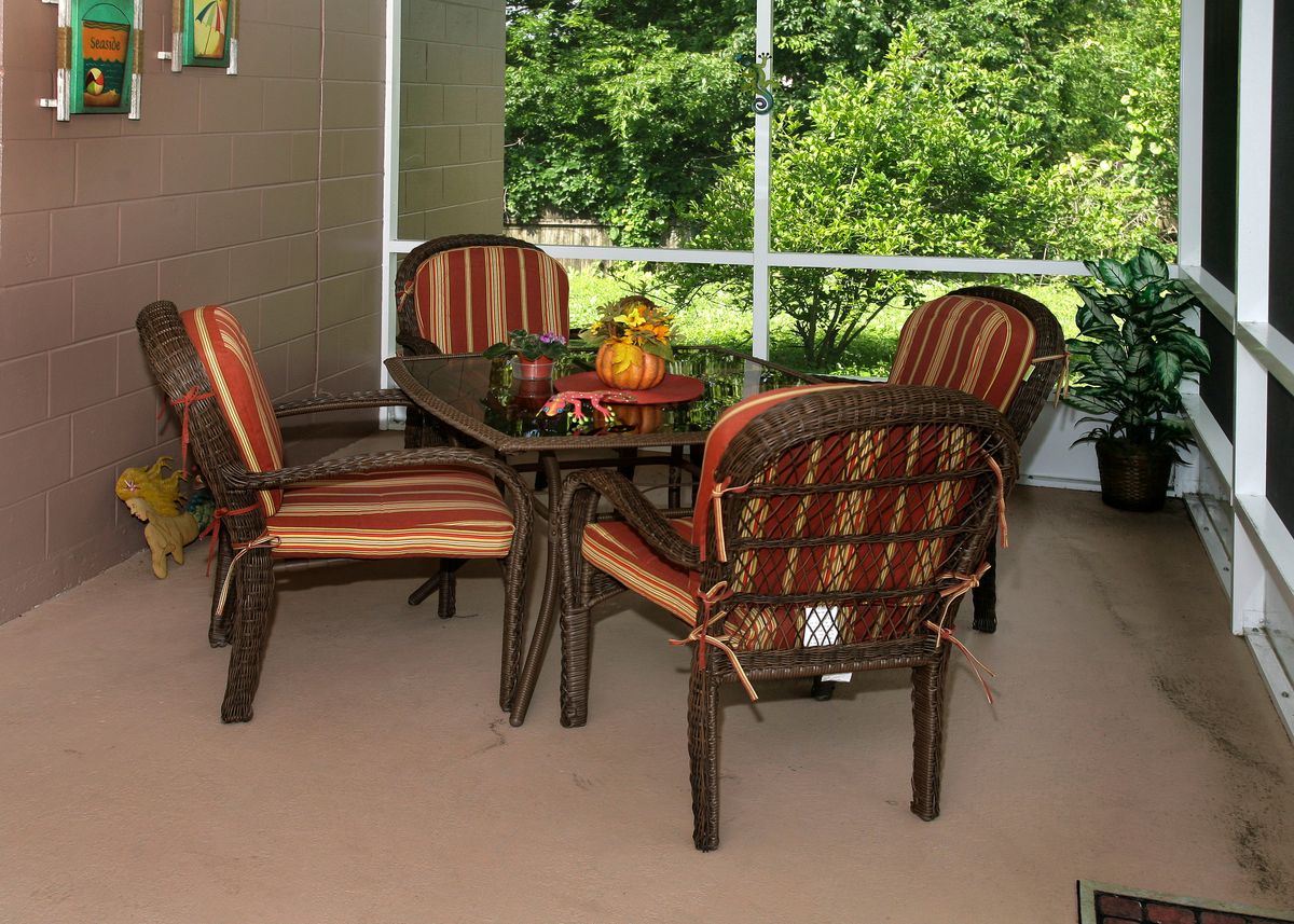 A cozy outdoor dining area with cushioned chairs and a table on a patio.