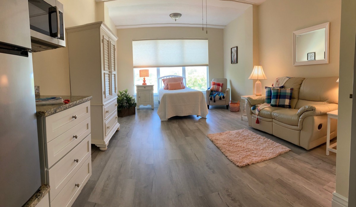 A cozy and well-lit bedroom with stylish decor and wooden flooring.