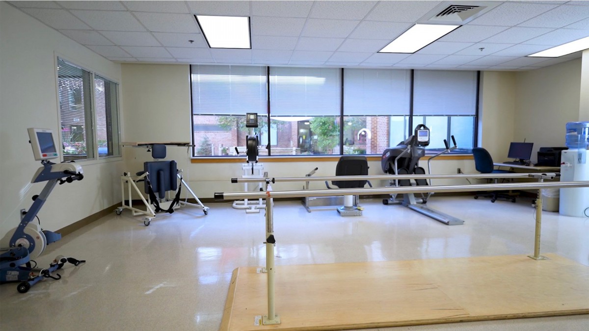 A well-lit physical therapy room with various gym equipment.