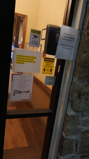 A view of the entrance door with various informational and warning signs displayed.