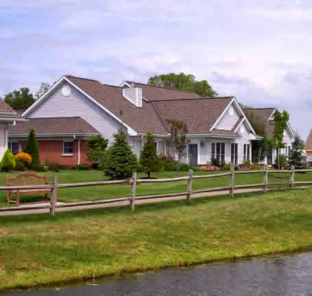 A beautiful residential house surrounded by a well-maintained lawn and fence.