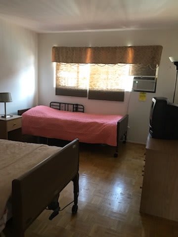 A cozy bedroom with a single bed, window, and essential furnishings.