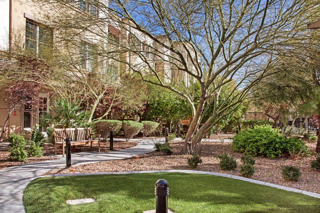 A serene garden with trees and a pathway next to a building.