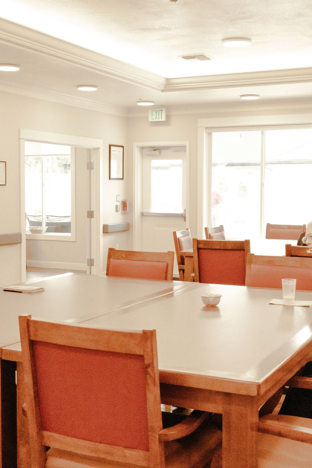 A bright and empty room with a table and chairs arranged around it.
