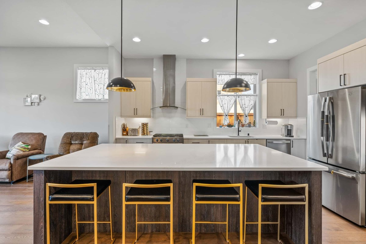 A modern kitchen with a large island, stylish pendant lighting, and sleek appliances.