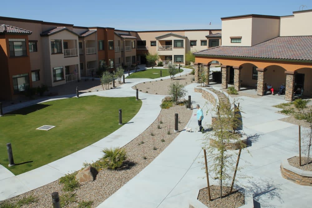 A landscaped courtyard in a residential apartment complex with walkways and greenery.