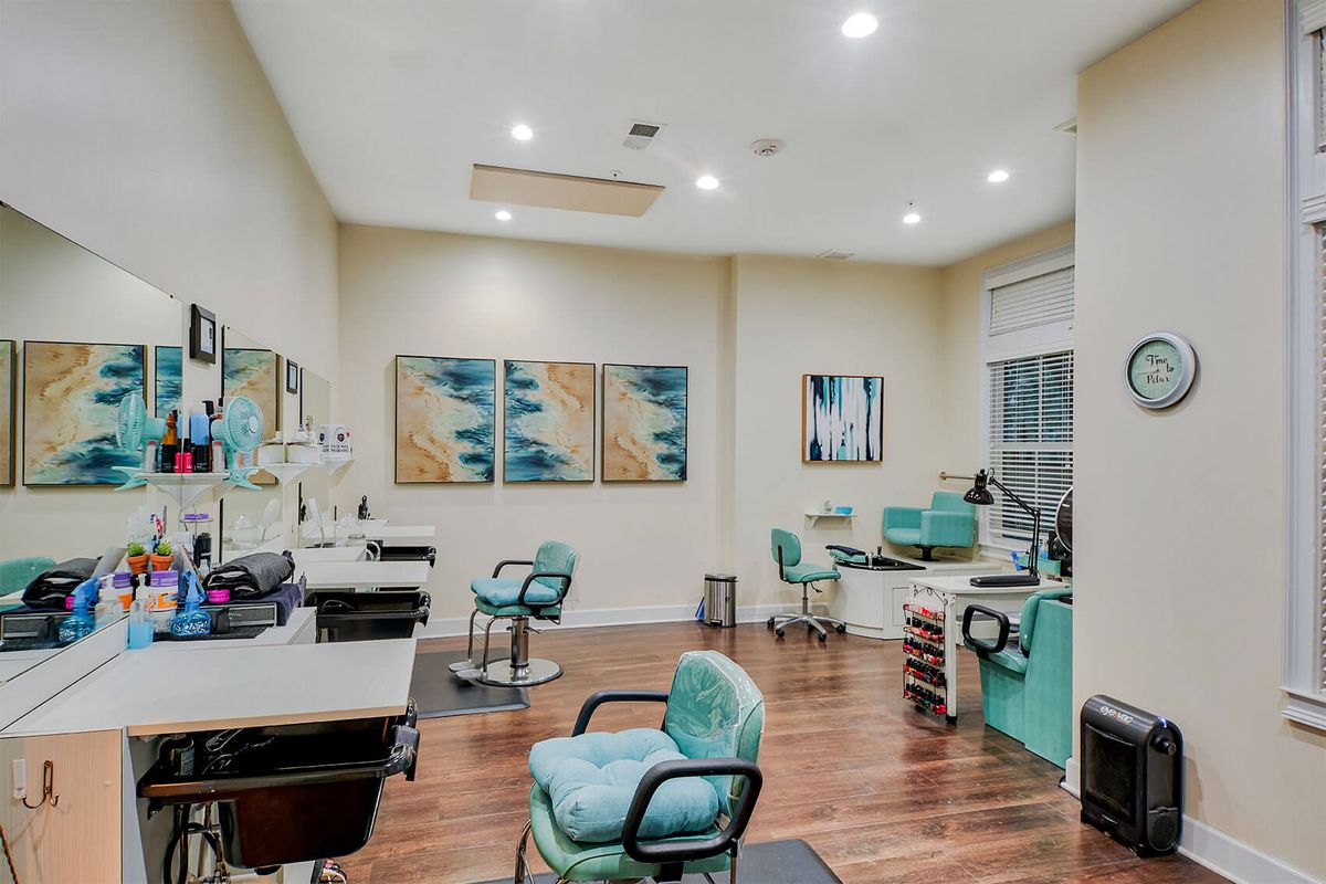 A modern salon interior with stylish chairs, mirrors, and decorative artwork.