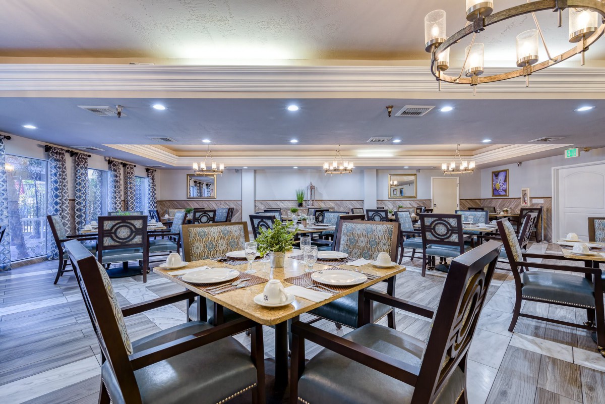 An elegant dining area with neatly arranged tables and chairs, showcasing sophisticated lighting and decor.