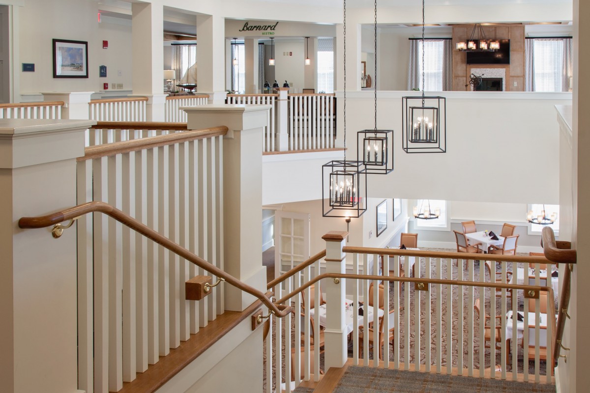 A modern interior featuring a staircase with elegant light fixtures and a spacious, open design.