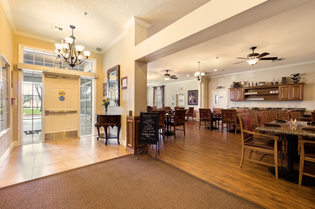 A spacious dining room with elegant furniture and a chandelier.