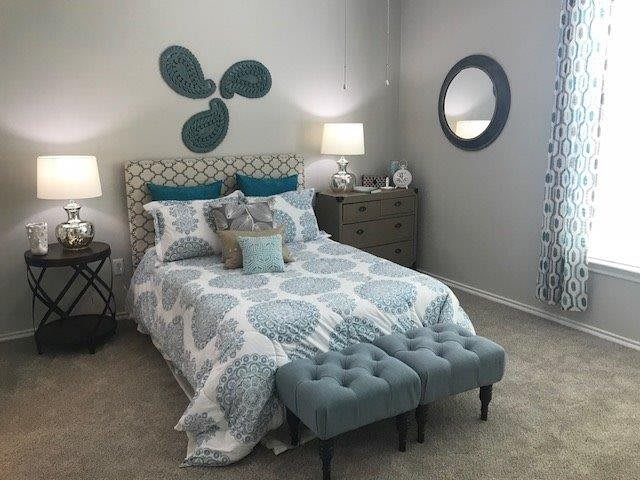 A stylishly decorated modern bedroom with teal and neutral color tones.