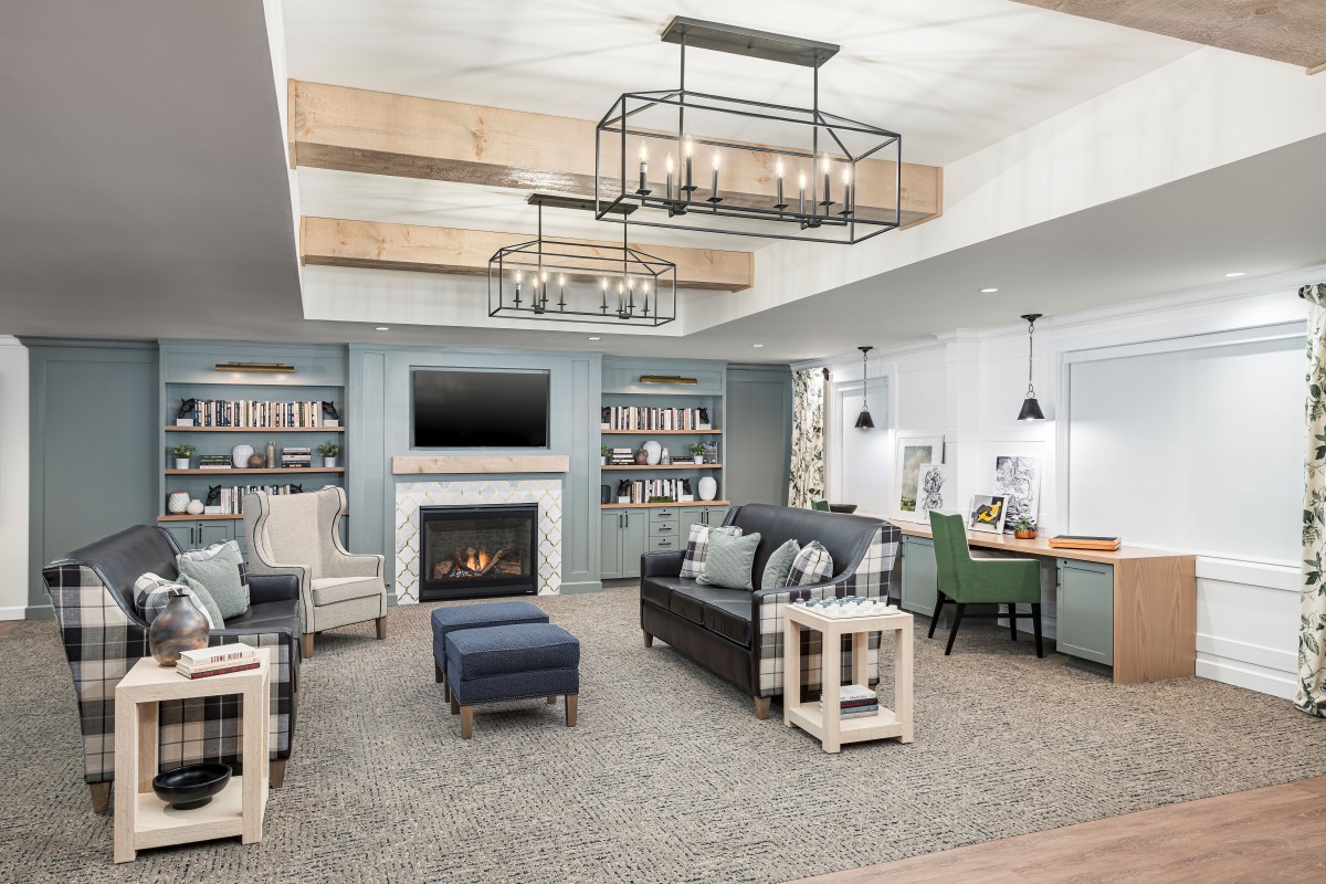 A cozy and stylish living room featuring a fireplace, modern lighting, and comfortable seating.