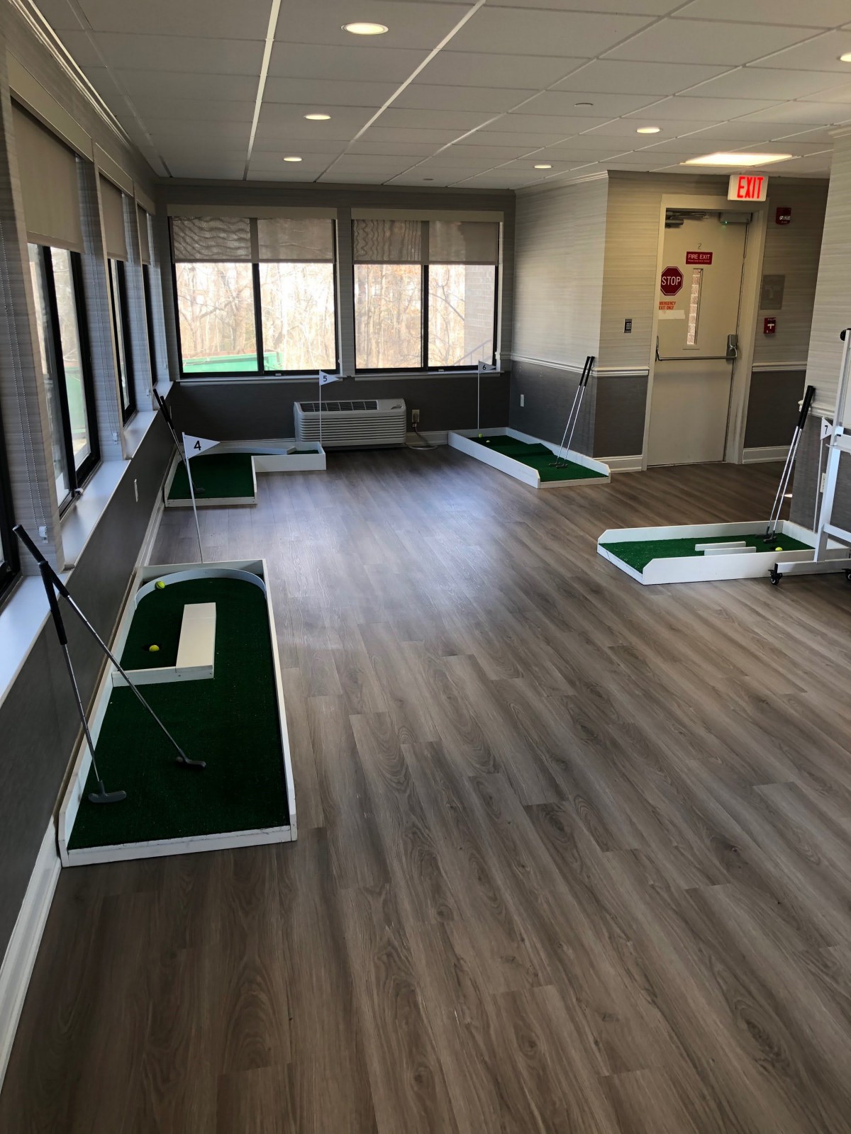 An indoor golf putting practice area with multiple stations.