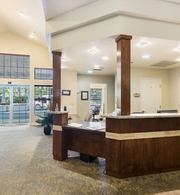 A spacious office reception area with a wooden desk and comfortable seating.