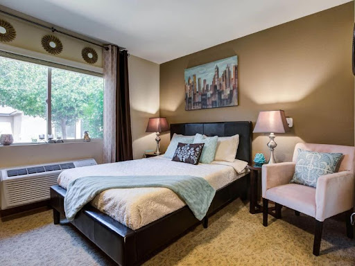 A cozy and stylish bedroom featuring a comfortable bed, warm lighting, and a modern aesthetic.