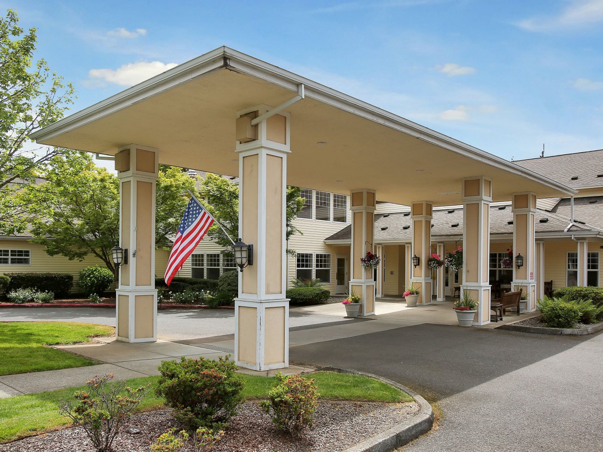 Entrance of a building with a covered walkway and an American flag.