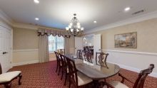 A well-decorated dining room with a large table and elegant chandelier.