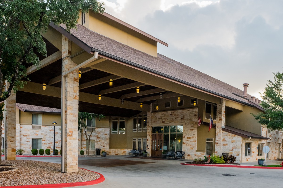 The entrance of a hotel with covered driveway and stone facade.