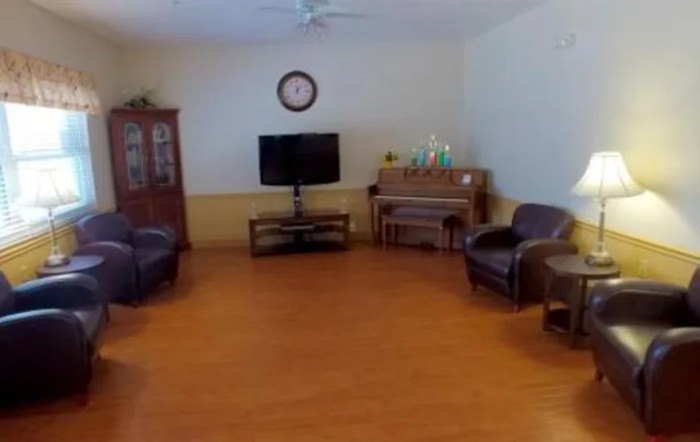 A spacious living room featuring a television, piano, and comfortable seating.