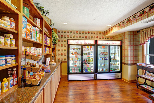 A cozy grocery store interior featuring shelves filled with snacks and two freezer displays.