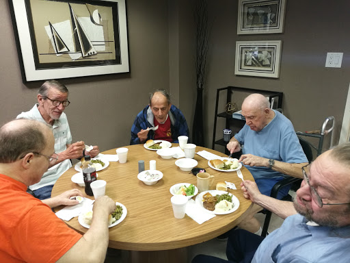 A group of individuals enjoying a meal together around a table.