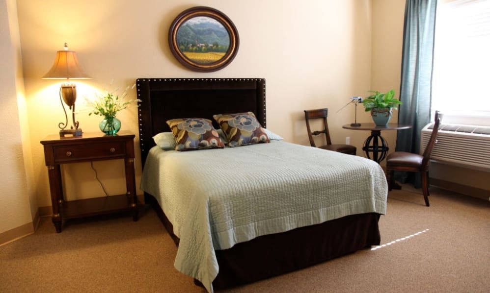 A cozy bedroom with a neatly made bed, decorative pillows, and warm lighting.