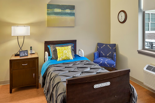 A cozy bedroom featuring a comfortable bed, armchair, and decor that creates a calming atmosphere.