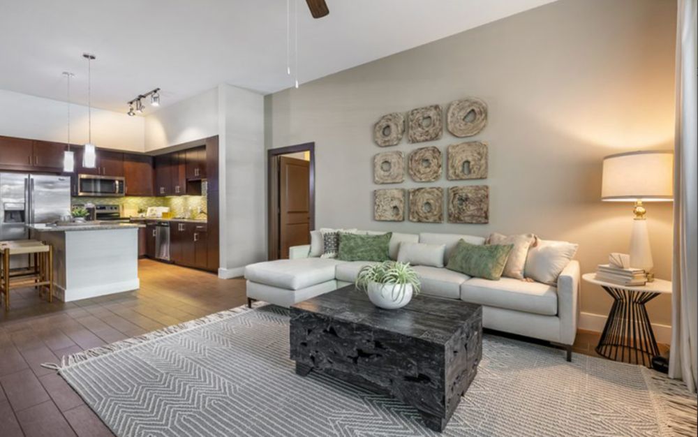 A modern open-concept living room with a comfortable sofa, stylish coffee table, and wall decor.