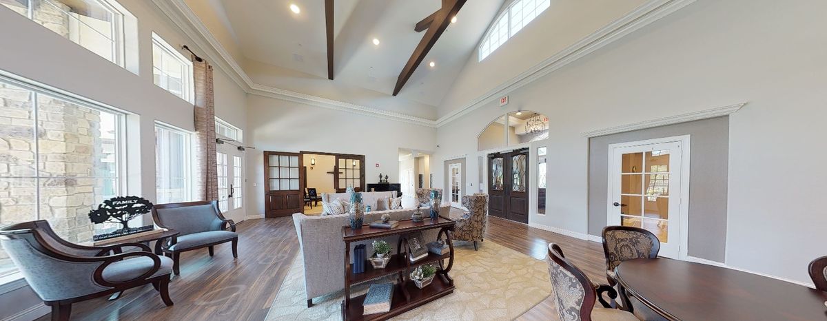 Spacious living room with vaulted ceilings and wooden beams, featuring cozy seating and elegant decor.