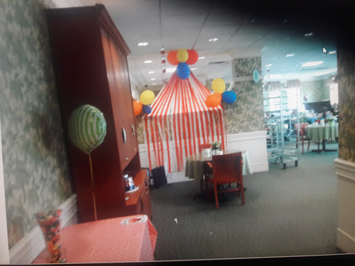 A festive indoor setting decorated with colorful balloons and a striped tent, perfect for a celebration.