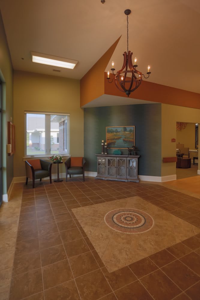 A warmly decorated lobby featuring a seating area and chandelier.