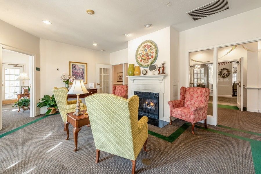 A cozy living room with comfortable armchairs, a fireplace, and elegant decor.