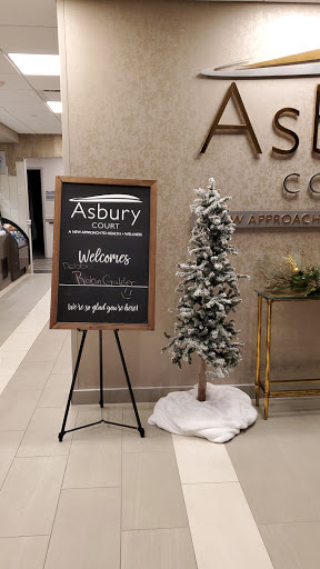 A welcoming entrance at Asbury Court featuring a holiday-themed decor and a chalkboard sign.