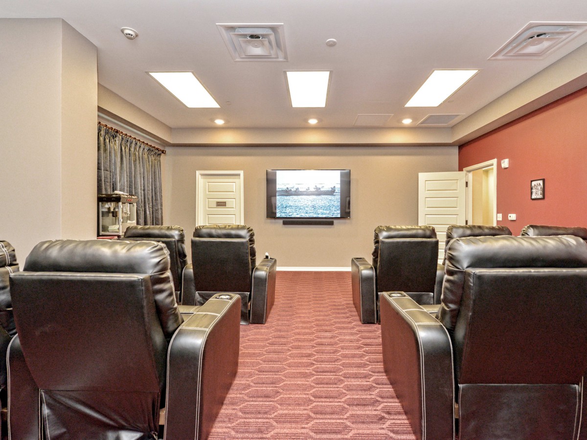 A cozy home theater room with comfortable seating and a large screen.