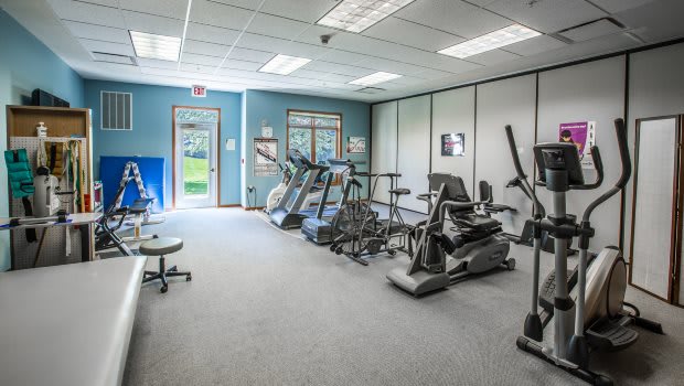 A gym room featuring various exercise machines, including treadmills and a stationary bike.