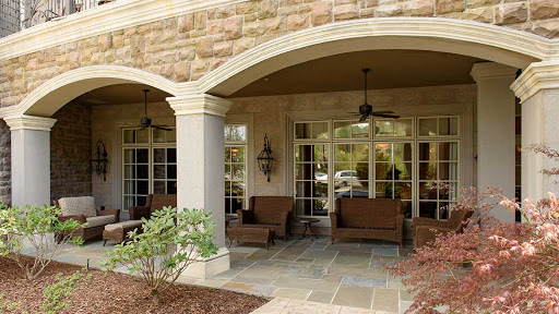 A peaceful outdoor patio featuring comfortable seating and elegant stone architecture.