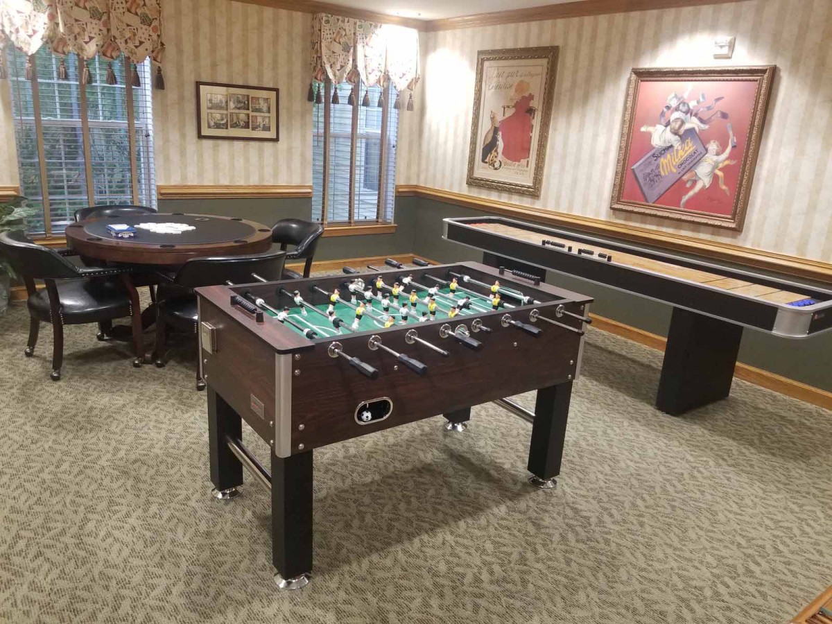 A cozy game room featuring a foosball table and shuffleboard, perfect for indoor entertainment.