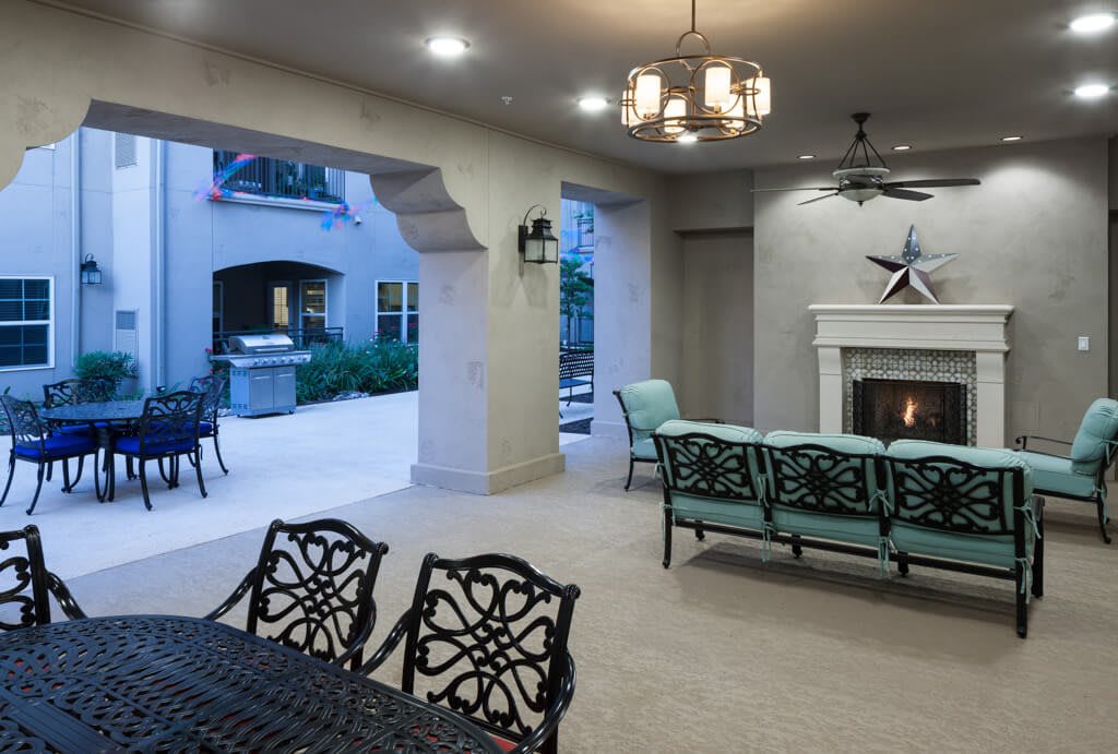 A cozy outdoor patio with a fireplace and elegant seating, perfect for evening relaxation.