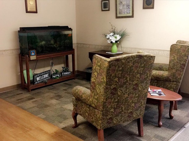 A cozy waiting room featuring a fish tank and comfortable seating.
