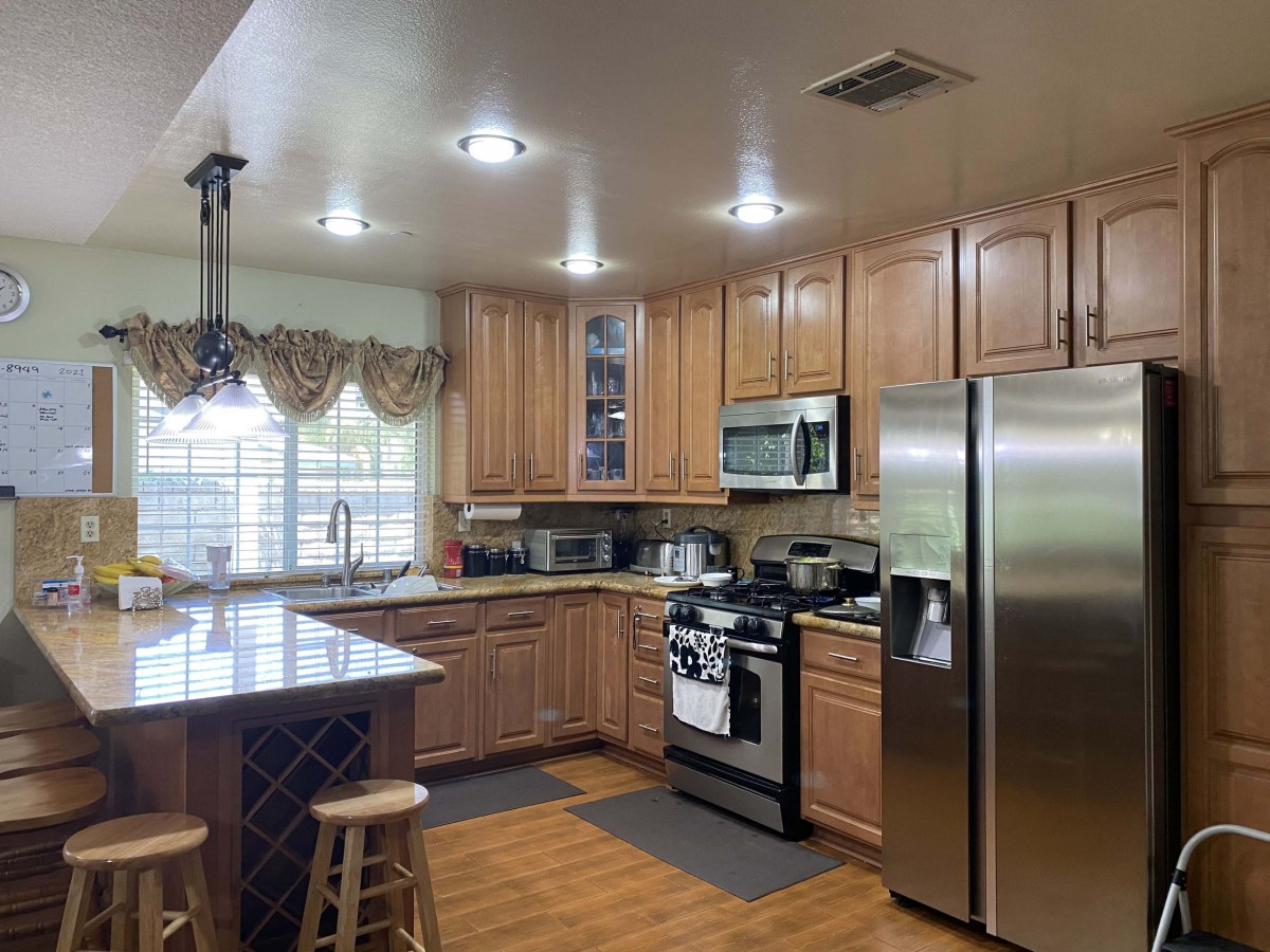 A modern kitchen with wooden cabinets and stainless steel appliances.