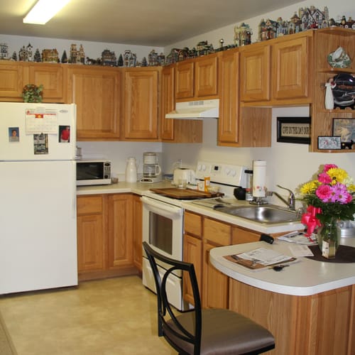 A cozy kitchen with wooden cabinets and various appliances.