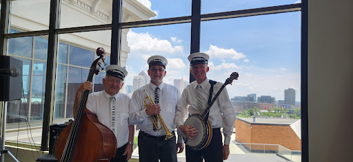 A lively trio of musicians poised to entertain with their brass and string instruments, showcasing a sunny day backdrop.